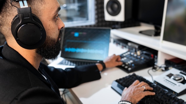 Kostenloses Foto junger mann, der an einem radiosender drinnen arbeitet