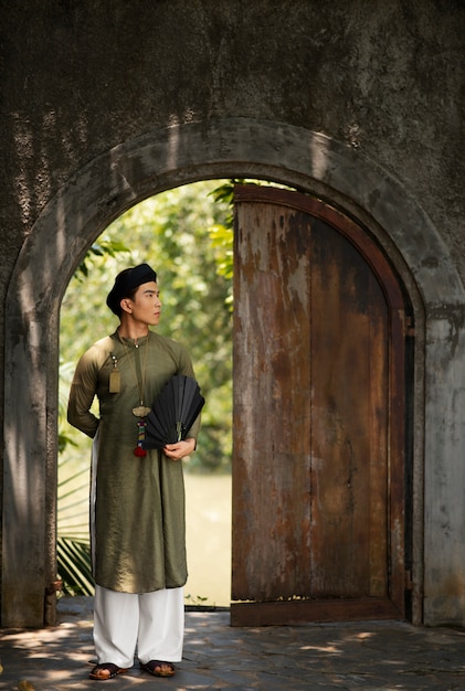 Junger Mann, der Ao-Dai-Kostüm trägt