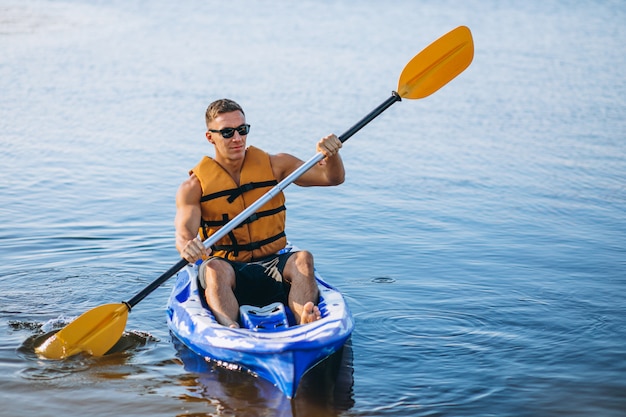 Junger Mann, der auf dem Fluss Kayak fährt