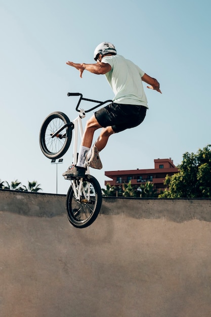 Junger Mann, der auf ein BMX-Fahrrad im Skatepark fährt
