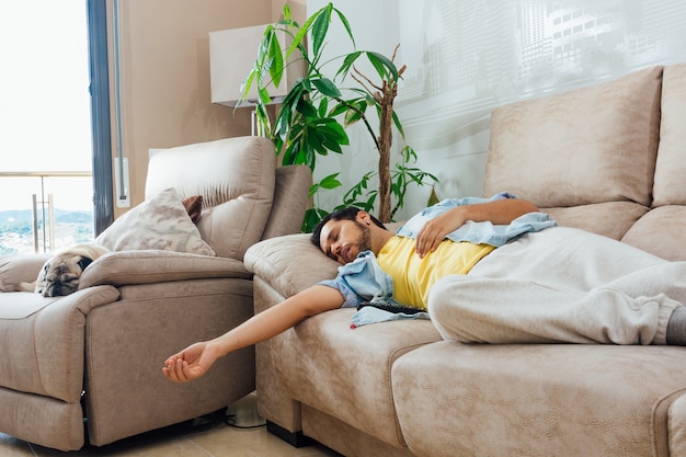 Junger Mann, der auf einem Sofa schläft