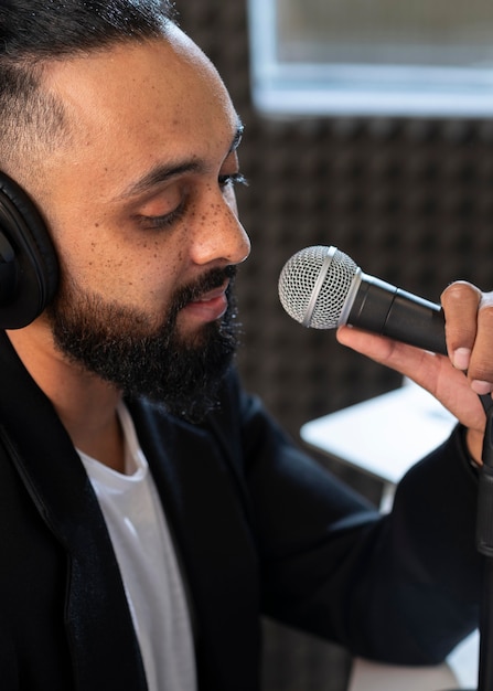 Kostenloses Foto junger mann, der bei einem radiosender arbeitet