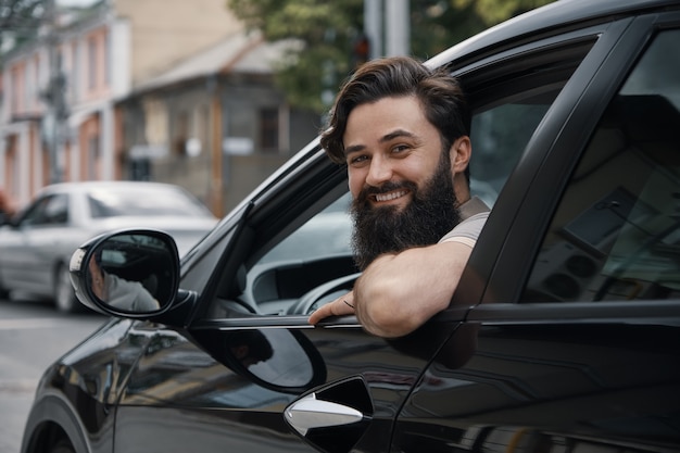 Junger mann, der beim autofahren lächelt