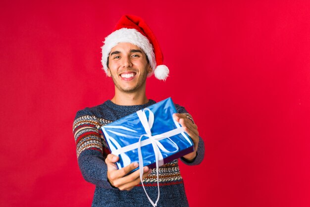 Junger Mann Der Ein Geschenk Am Weihnachtstag Halt Premium Foto