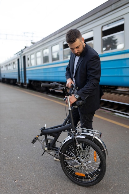 Junger Mann, der ein Klapprad benutzt, während er mit dem Zug fährt