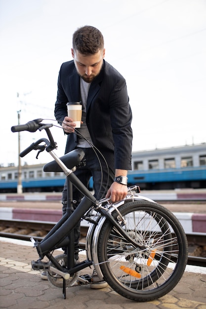 Kostenloses Foto junger mann, der ein klapprad benutzt, während er mit dem zug fährt