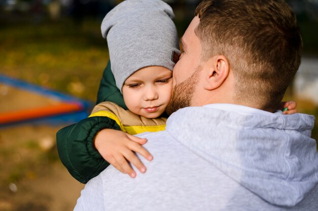 Junger Mann, der einen Jungen in seinen Armen hält