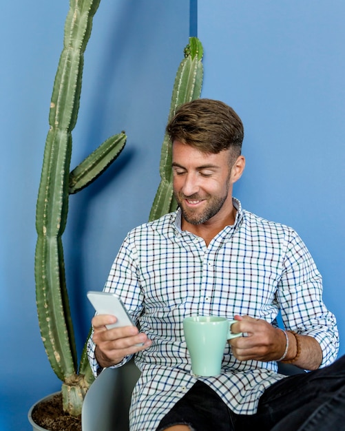 Kostenloses Foto junger mann, der einen kaffee trinkt