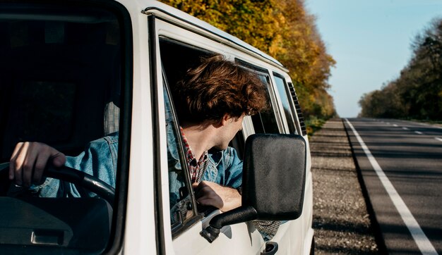 Junger Mann, der einen Roadtrip in seinem Van hat