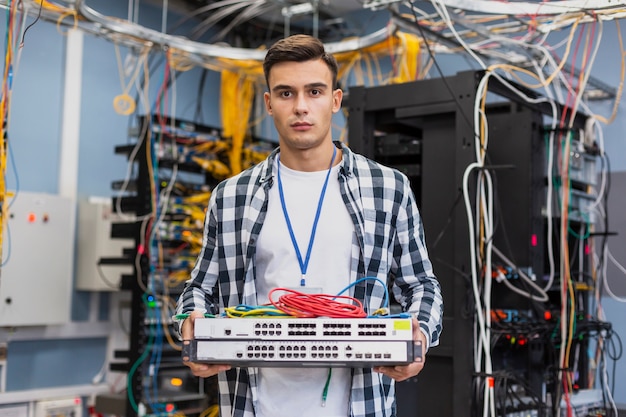 Kostenloses Foto junger mann, der ethernet-schalter hält