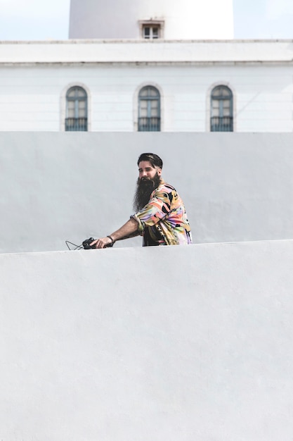 Junger Mann, der Fahrrad vor Wand fährt