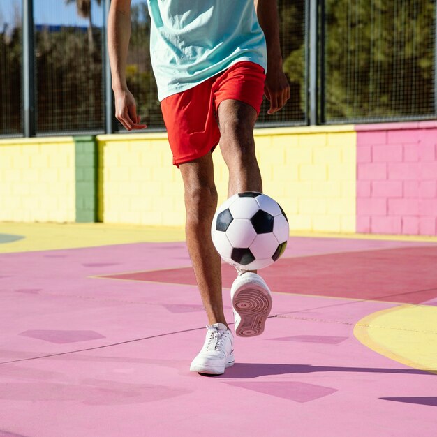 Junger Mann, der Fußball Nahaufnahme spielt