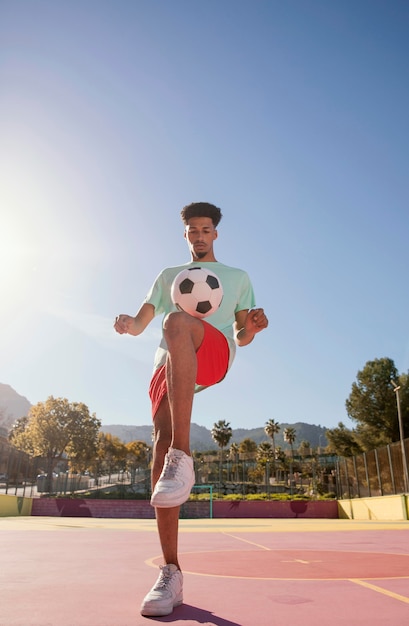 Junger Mann, der Fußball spielt