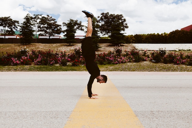 Kostenloses Foto junger mann, der handstand ausübt