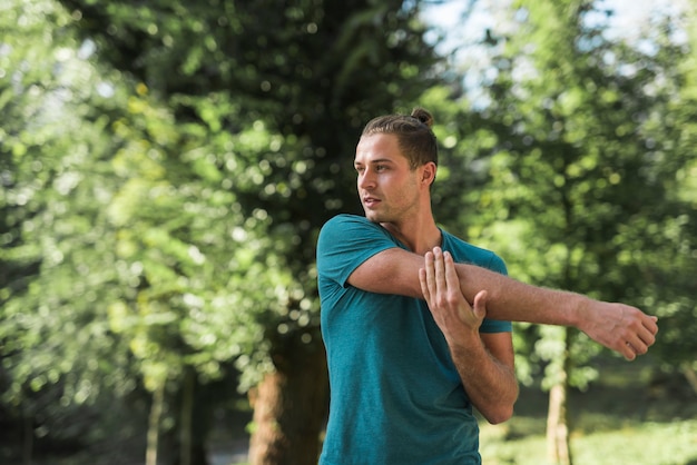 Junger Mann, der in den Park ausdehnt