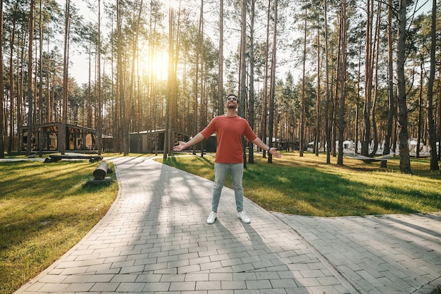 Junger Mann, der in der Parkzone spaziert