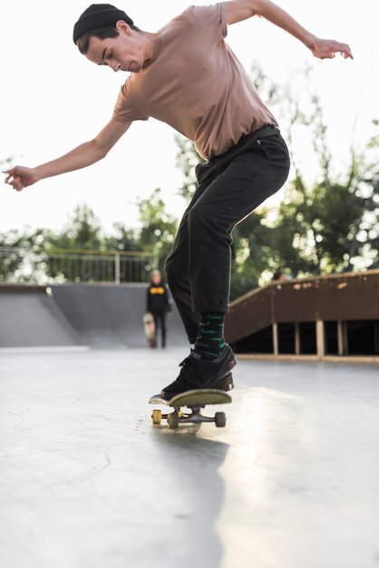 Junger Mann, der in die Straße Skateboard fährt