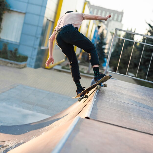 Junger Mann, der in die Straße Skateboard fährt