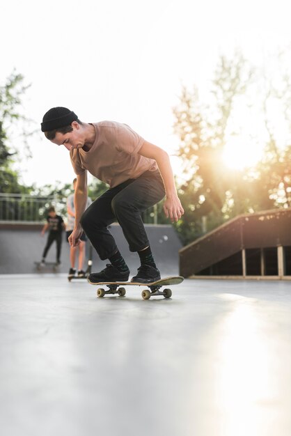 Junger Mann, der in die Straße Skateboard fährt