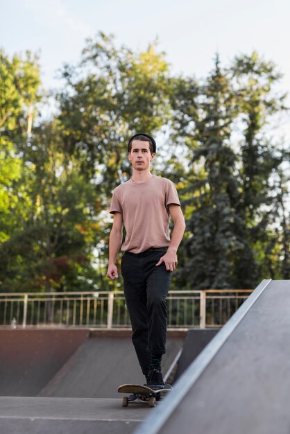 Junger Mann, der in die Straße Skateboard fährt
