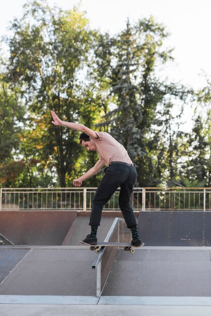 Junger Mann, der in die Straße Skateboard fährt