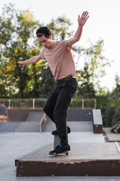 Junger Mann, der in die Straße Skateboard fährt