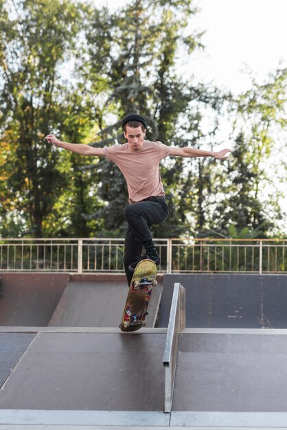 Junger Mann, der in die Straße Skateboard fährt