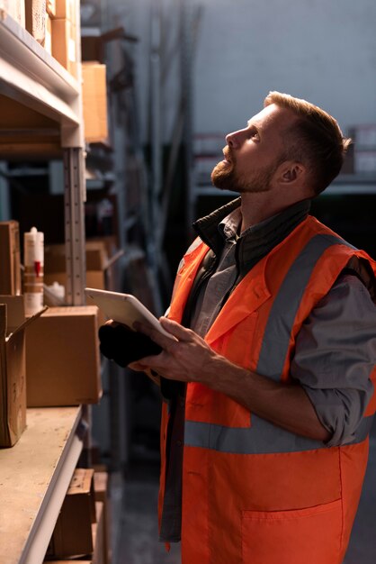 Junger Mann, der in einem Lager arbeitet