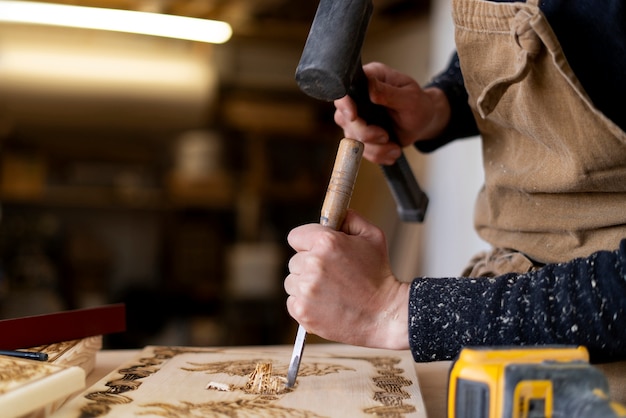 Junger Mann, der in einer Holzstichwerkstatt arbeitet