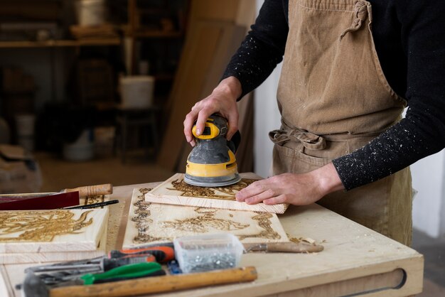 Junger Mann, der in einer Holzstichwerkstatt arbeitet