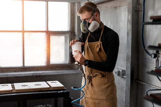 Kostenloses Foto junger mann, der in einer holzstichwerkstatt arbeitet