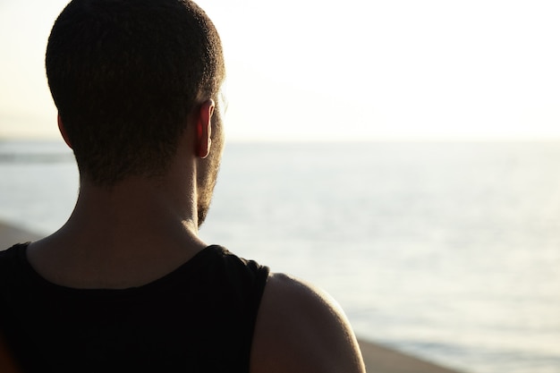 Junger Mann, der Landschaft am Strand bewundert