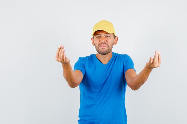 Junger Mann, der Meditation im blauen T-Shirt tut