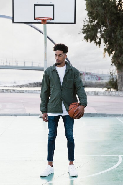 Junger Mann, der mit Basketballball aufwirft