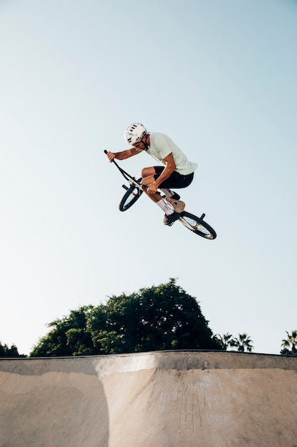 Junger Mann, der mit bmx Fahrrad springt