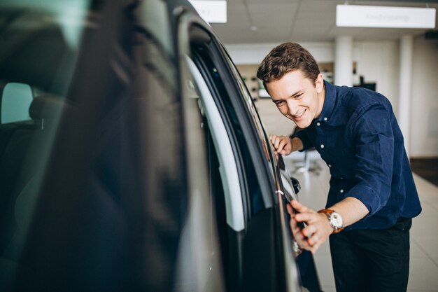 Junger Mann, der nach einem Auto sucht, um zu mieten