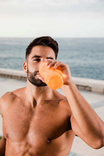 Junger Mann, der nach Training im Freien hydratisiert