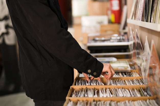 Junger Mann der Nahaufnahme, der nach Vinyls im Speicher sucht