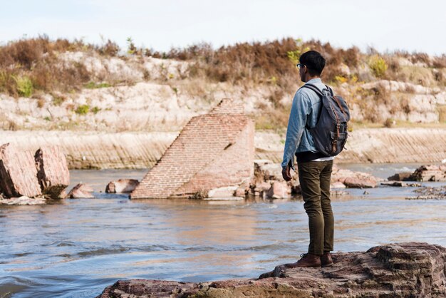 Junger Mann, der nahes Wasser steht