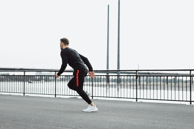 Junger Mann, der Sport in einer europäischen Stadt spielt. Sport in urbanen Umgebungen.