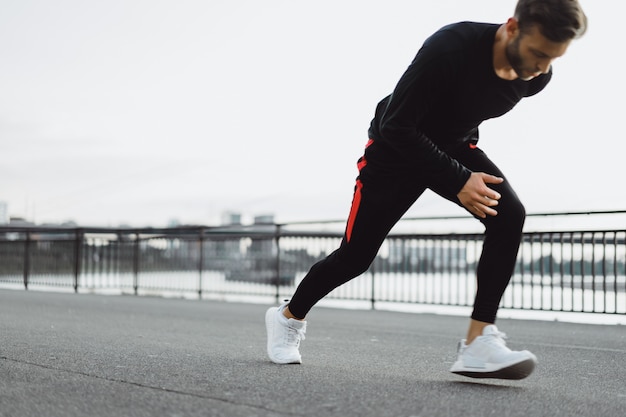 Junger Mann, der Sport in einer europäischen Stadt spielt. Sport in urbanen Umgebungen.