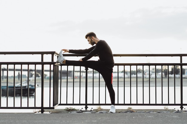 Junger Mann, der Sport in einer europäischen Stadt spielt. Sport in urbanen Umgebungen.