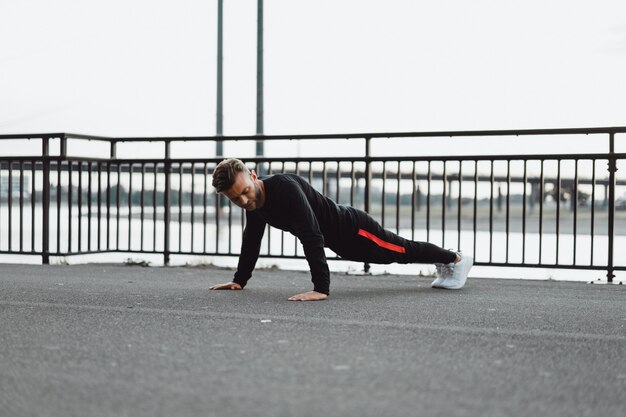 Junger Mann, der Sport in einer europäischen Stadt spielt. Sport in urbanen Umgebungen.