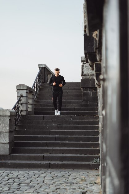 Junger Mann, der Sport in einer europäischen Stadt spielt. Sport in urbanen Umgebungen.