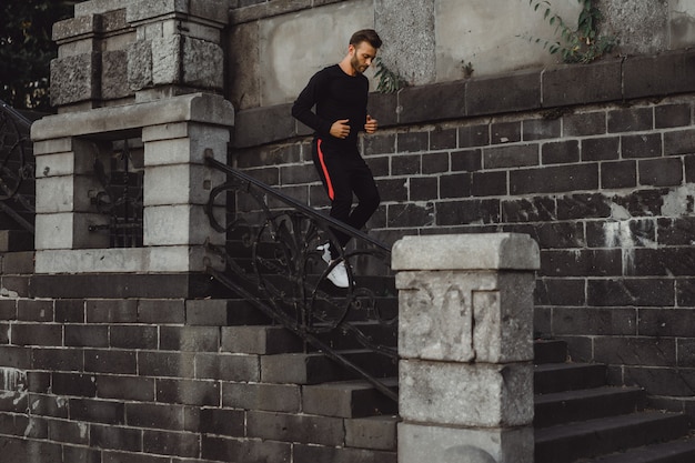 Junger Mann, der Sport in einer europäischen Stadt spielt. Sport in urbanen Umgebungen.