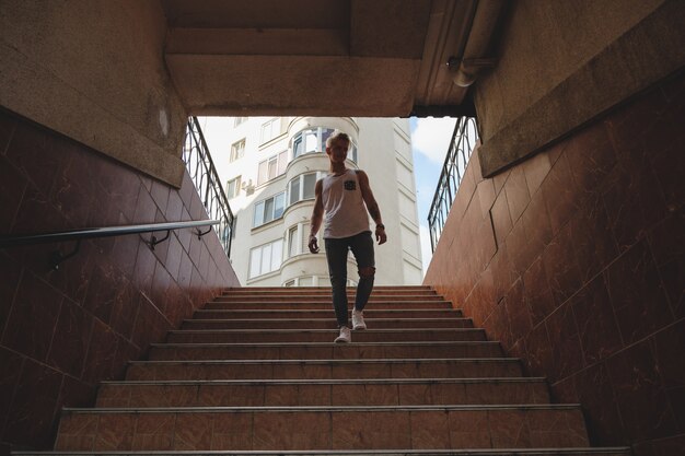 Junger Mann, der Treppe in der Fußgängeruntergrundbahn hinuntergeht