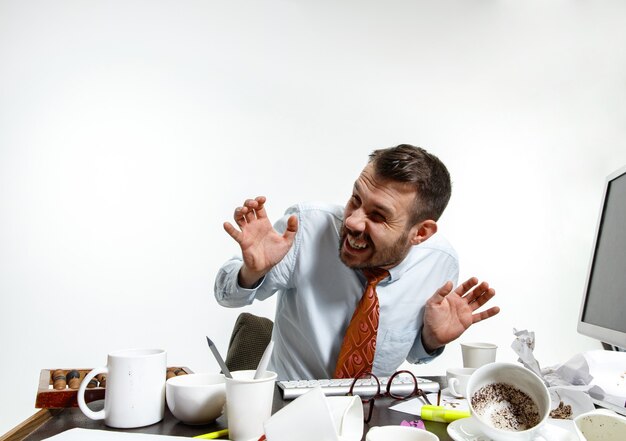 Junger Mann, der unter dem Lärm im Büro leidet