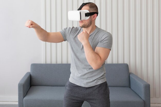 Junger Mann, der Videospiele spielt, während er eine Virtual-Reality-Brille trägt