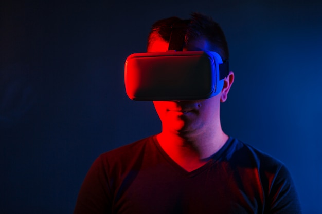 Junger Mann, der VR-Kopfhörer trägt und virtuelle Realität erlebt.