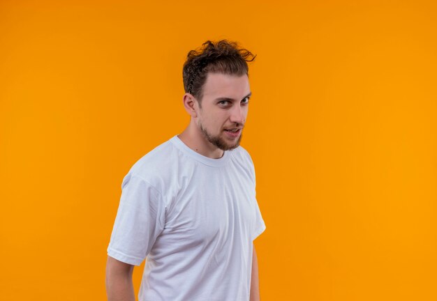 junger Mann, der weißes T-Shirt auf isolierter orange Wand trägt